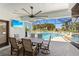 Outdoor patio with a dining table, a ceiling fan, and a view of the pool and palm trees at 4001 La Costa Island Ct, Punta Gorda, FL 33950