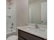 This bathroom has a shower-tub combination, a dark vanity, a stylish sink, and a large mirror at 4127 Snowdrop St, North Port, FL 34288