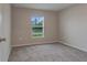 A simple bedroom showcases neutral walls, carpet flooring, and a window with natural light at 4127 Snowdrop St, North Port, FL 34288