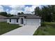 Inviting single-Gathering home featuring a concrete driveway leading to an attached garage at 4127 Snowdrop St, North Port, FL 34288