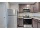 Functional kitchen featuring stainless steel appliances and dark wood cabinetry at 4127 Snowdrop St, North Port, FL 34288