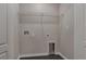 This laundry room has dark wood-look flooring, utility hookups, and shelving for storage at 4127 Snowdrop St, North Port, FL 34288