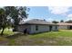 The back of this home shows a wide yard, a neutral paint scheme, and mature landscaping at 4127 Snowdrop St, North Port, FL 34288