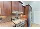 This kitchen showcases stainless steel appliances, granite countertops, and ample storage in custom wood cabinetry at 420 Wabash Ter, Port Charlotte, FL 33954