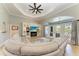 Bright living room with a large sectional, built-in shelving, and sliding doors leading to the patio at 420 Wabash Ter, Port Charlotte, FL 33954