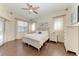 Bright main bedroom with wood floors, ceiling fan, and large windows, offering a serene retreat at 420 Wabash Ter, Port Charlotte, FL 33954