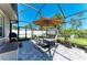 Covered outdoor dining area features a barbecue and table with seating, perfect for entertainment at 420 Wabash Ter, Port Charlotte, FL 33954
