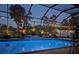 Beautiful pool with a brick patio, lovely greenery and decorative string lights for a resort atmosphere at 420 Wabash Ter, Port Charlotte, FL 33954