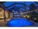 Inviting screened-in pool area featuring lush landscaping, an outdoor kitchen, and plenty of space for entertaining at 420 Wabash Ter, Port Charlotte, FL 33954