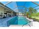 A relaxing screened-in pool area with a tiled pool and a comfortable seating area just outside the house at 420 Wabash Ter, Port Charlotte, FL 33954