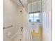 The shower features tiled walls, chrome fixtures, and a window to allow for natural lighting at 420 Wabash Ter, Port Charlotte, FL 33954