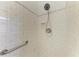 The bathroom features a shower with white tile, a shower head, and a grab bar for safety at 420 Wabash Ter, Port Charlotte, FL 33954