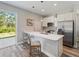 Modern kitchen featuring stainless steel appliances, bar seating, and quartz countertops by the patio door at 4343 Killdeer Ter, North Port, FL 34288