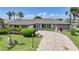 Charming home featuring a beautifully landscaped front yard, a fountain, and a circular paver driveway at 505 Via Cintia, Punta Gorda, FL 33950