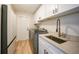 Laundry room with modern washer/dryer, sink, and white cabinetry at 505 Via Cintia, Punta Gorda, FL 33950