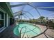 Screened-in pool with brick patio and partial view of surrounding neighborhood at 505 Via Cintia, Punta Gorda, FL 33950