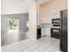 Bright kitchen with black appliances, ceramic tile floors, white cabinets, and neutral paint at 5121 Chaves Cir, Port Charlotte, FL 33948