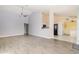 Open living room with vaulted ceiling flowing into kitchen with black appliances and ceramic tile floors at 5121 Chaves Cir, Port Charlotte, FL 33948