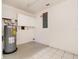 Bright utility room with a water heater, wall-mounted cabinets, and an electrical panel at 5121 Chaves Cir, Port Charlotte, FL 33948