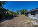 View of the spacious backyard with lush foliage, partial view of the screened patio and the side of the house at 7225 Sea Mist Dr, Port Charlotte, FL 33981