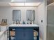 Bathroom with dual sinks, blue vanity with storage, and modern fixtures at 7225 Sea Mist Dr, Port Charlotte, FL 33981
