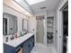 Bright bathroom features double sink vanity, glass shower, and linen closet at 7225 Sea Mist Dr, Port Charlotte, FL 33981