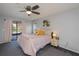 Bedroom features a ceiling fan and a sliding glass door to the screened lanai at 7225 Sea Mist Dr, Port Charlotte, FL 33981