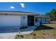 Close up of the front of the home with an attached garage and decorated with sunflowers at 7225 Sea Mist Dr, Port Charlotte, FL 33981