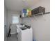 Efficient laundry room featuring a modern washer, dryer, and ample shelving for storage at 7225 Sea Mist Dr, Port Charlotte, FL 33981