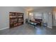 Inviting living room showcasing a brown leather sofa, a large bookcase, and natural light from a bay window at 7225 Sea Mist Dr, Port Charlotte, FL 33981