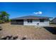 Home with a screened-in lanai and simple design under a blue sky and green trees at 7225 Sea Mist Dr, Port Charlotte, FL 33981
