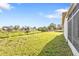 View of the home's spacious lawn with a view of a green space and neighboring houses at 8172 Trionfo Ave, North Port, FL 34287