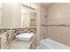 Bright bathroom showcasing a modern vessel sink atop granite counters and a tub with tiled surround at 8172 Trionfo Ave, North Port, FL 34287