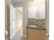 Bathroom with wood vanity, dark countertop, tile backsplash, and linen closet at 8172 Trionfo Ave, North Port, FL 34287