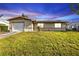 A charming single-story home with well-kept lawn, lit by a beautiful twilight sky at 8172 Trionfo Ave, North Port, FL 34287