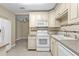 A bright kitchen boasts white appliances, white cabinetry and tiled backsplash at 8172 Trionfo Ave, North Port, FL 34287