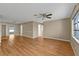 Open-concept living room featuring wood floors, neutral walls, and a ceiling fan at 8172 Trionfo Ave, North Port, FL 34287