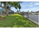 Large backyard with lush grass and a view of the canal and neighboring houses at 859 Napoli Ln, Punta Gorda, FL 33950