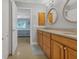 Bathroom featuring double sinks and wooden cabinets with view into a bedroom at 859 Napoli Ln, Punta Gorda, FL 33950