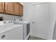Laundry room with washer, dryer, and wooden cabinets at 859 Napoli Ln, Punta Gorda, FL 33950