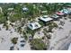 Coastal community featuring homes on stilts surrounded by lush foliage and sandy shores at 8754 King St, Placida, FL 33946