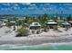 Coastal homes featuring metal roofs and situated on white sand near the ocean at 8754 King St, Placida, FL 33946