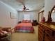 Cozy bedroom with plush pink bedding, ceiling fan and natural light at 8754 King St, Placida, FL 33946