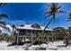 Charming elevated beach house with weathered wood exterior and metal roof near palm trees at 8754 King St, Placida, FL 33946