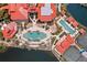 Aerial view of a luxurious pool, surrounded by palms and lounge chairs, as well as tennis courts and red-roofed buildings at 93 Vivante Blvd # 9344, Punta Gorda, FL 33950