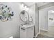 Bright bathroom featuring a round mirror, stylish peacock decor, and white marble vanity at 93 Vivante Blvd # 9344, Punta Gorda, FL 33950