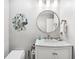 Bright bathroom featuring a round mirror, stylish peacock decor, and white marble vanity at 93 Vivante Blvd # 9344, Punta Gorda, FL 33950