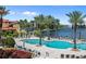 Community pool with plenty of seating and beautiful landscaping, palm trees and lake views add to the beauty at 93 Vivante Blvd # 9344, Punta Gorda, FL 33950