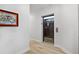 Hallway leading to an elevator with a decorative art piece on the wall at 93 Vivante Blvd # 9344, Punta Gorda, FL 33950