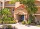 Condo entrance with landscaping, a tile roof, pillars and signage for 